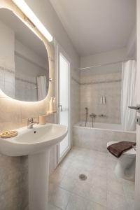 a white bathroom with a sink and a tub at To Pelagos in Agios Sostis +102 photos