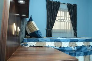 a bed in a room with a window at Besta Apartments in Akure