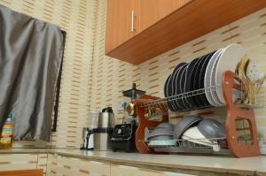 a kitchen counter with a drying rack with dishes at Besta Apartments in Akure