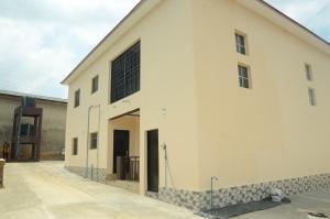 a large white building with a large window at Besta Apartments in Akure