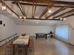 a dining room with tables and chairs and wooden ceilings at Casa Keea in Moieciu de Sus