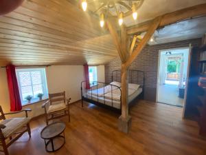 a bedroom with a bed in a room with wooden ceilings at Den Doezel in Vorden