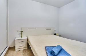 a white bedroom with a bed with a blue towel on it at Espanhouse Pinada Beach in La Marquesa +46 photos
