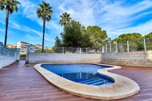a swimming pool with a brick wall and palm trees at Espanhouse Pinada Beach in La Marquesa