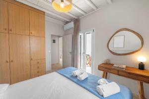 a bedroom with a bed and a mirror at To Pelagos in Agios Sostis