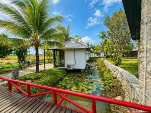 a house with a pond with a red fence at LUA Farmstay in Bà Rịa +28 photos