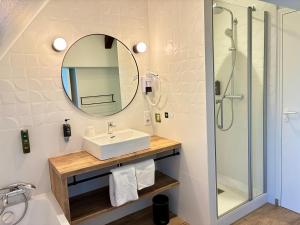 a bathroom with a sink and a mirror at Logis Hôtel & Restaurant - Le Saint-Louis in La Suze-sur-Sarthe +44 photos