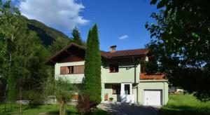a white house with a tree in front of it at Appartement Dallavia in Sankt Johann im Walde