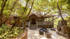 a house in the woods with a porch at Chambers Mahabaleshwar, A Club Mahindra Associate Resort in Mahabaleshwar