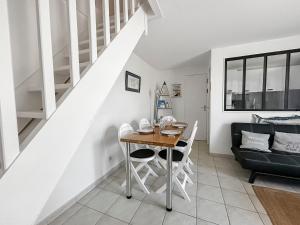 a living room with a table and a couch at Maisonnette cosy avec jardin - proche port et plage in Dives-sur-Mer