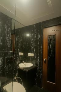 a black bathroom with a sink and a mirror at Umed in Jodhpur +25 photos