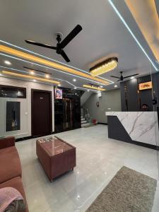 a living room with a ceiling fan and a couch at Hotel Mahadev Palace in Kankhal