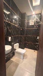 a bathroom with a toilet and a sink at Hotel Mahadev Palace in Kankhal +18 photos