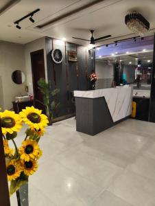 a lobby with yellow sunflowers and a reception desk at Hotel Mahadev Palace in Kankhal