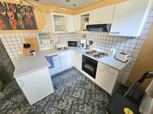a small kitchen with white cabinets and appliances at Ferienwohnung in der Siedlung in Klinga