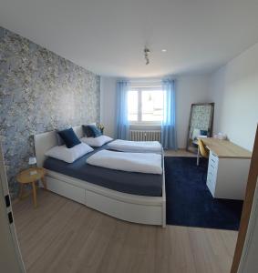 a bedroom with a large bed and a desk at Ferienwohnung Weitblick in Dachau