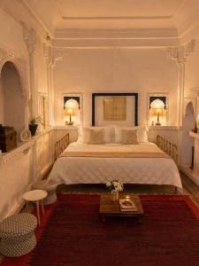 a bedroom with a large bed and a table at Garh Harsolav in Harsolāv