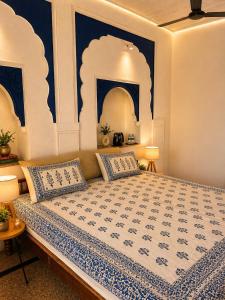 a bedroom with a large bed with blue and white walls at Garh Harsolav in Harsolāv