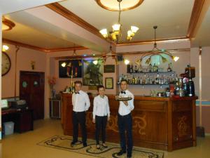 um grupo de três homens em pé em frente a um bar em Pensiunea Romeo Tecuci em Tecuci