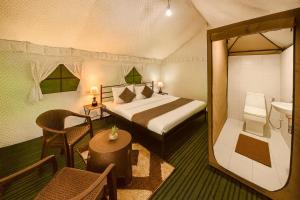 a hotel room with a bed and a bathroom at The Himalayan Swiss Cottage with Bonfire, Manali - A Riverside Retreat in Manāli
