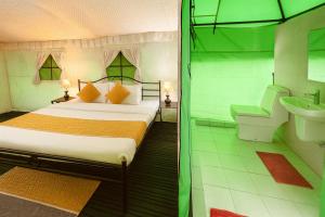 a bedroom with a bed and a bathroom with a sink at The Himalayan Swiss Cottage with Bonfire, Manali - A Riverside Retreat in Manāli