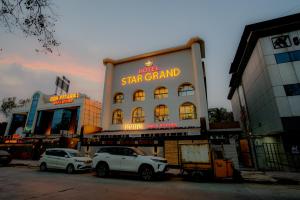 two white cars parked in front of a star grand at Mosaic Go Star Grand in Navi Mumbai