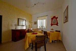 a dining room with two tables with yellow table cloth at Borgo della Rocca in Montemurlo