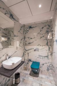 a bathroom with a white sink and a blue bowl at Mosaic Go Star Grand in Navi Mumbai
