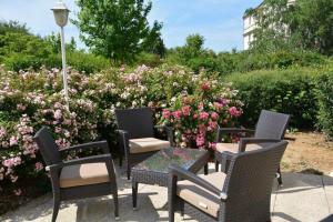 a group of chairs and a table in front of flowers at Campanile Marne la Vallée - Bussy Saint-Georges in Bussy-Saint-Georges