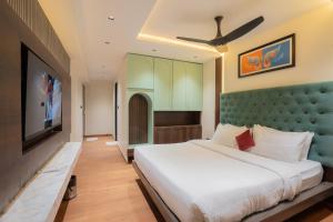 a bedroom with a large bed and a flat screen tv at Mosaic Go Star Grand in Navi Mumbai