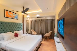 a bedroom with a large bed and a flat screen tv at Mosaic Go Star Grand in Navi Mumbai +10 photos