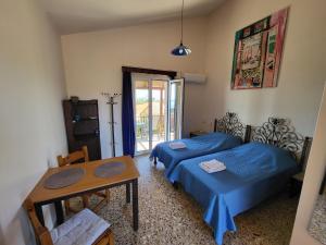 a bedroom with two beds and a table and a table sidx sidx sidx at Filippos Apartments "Room 6" in Spartià