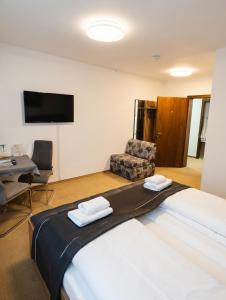 a hotel room with a large bed and a chair at Hotel Kühns Mühle in Oestrich-Winkel