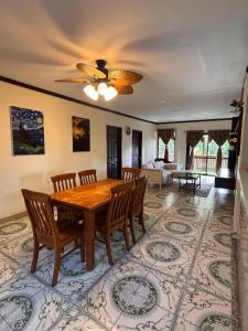 a dining room with a wooden table and chairs at Linas Lodge in Vaitele