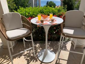two chairs and a table with drinks on a patio at Delux apartment Dora with a private parking in Rijeka