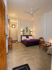 a bedroom with a bed and two chairs in it at One FS Hotel Arugambay in Arugam Bay