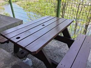 a wooden picnic table sitting next to a fence at Gyeongsan Annex Pension in Gyeongsan +33 photos