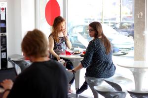 dos mujeres de pie en una mesa en una tienda en Botxo Gallery - Youth Hostel Bilbao, en Bilbao