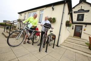 a man and a woman standing next to their bikes at The Lindisfarne Inn - The Inn Collection Group in Beal
