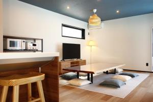 a living room with a table and a tv at Nord SUR in Ichinomiya