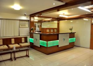 a lobby with a waiting room with benches and a counter at Hotel Happiness in Surat