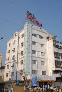 un edificio blanco con un cartel encima en Hotel Happiness en Surat