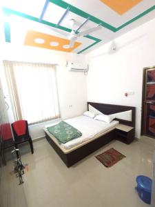 a bedroom with a bed and a chair and a ceiling at Hotel Vishal in Buxar