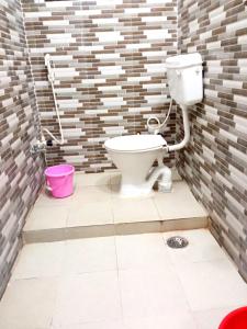 a bathroom with a toilet in a brick wall at Hotel Vishal in Buxar +12 photos