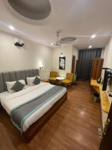 a hotel room with a bed and a table and chairs at Aamod Feather Touch - Nainital in Nainital