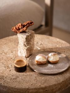 a table with a plate of donuts and a plate at Nomos Hotel in Rome +66 photos