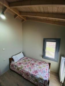 a bedroom with a bed and a window at Athos view house in Agios Ioannis Kaspaka