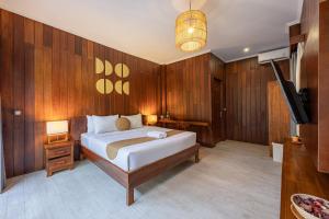a bedroom with a bed and a flat screen tv at Cove Dadeka in Canggu