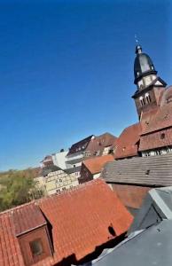 a view of a building with a tower and roofs at Pension Quartier 11 in Waren