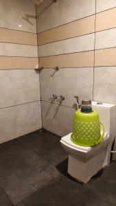 a green pot sitting on a toilet in a bathroom at Hill valley farm resort in Munnar